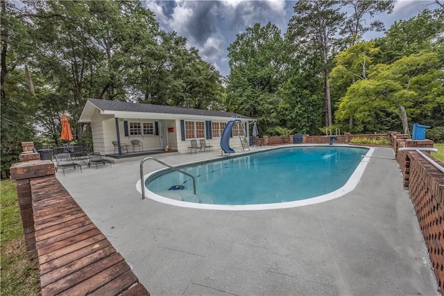 406 Saint Francis Rd, Eufaula, AL 36027 - view of pool featuring a water slide, a patio, an outdoor structure, view of wooded area, and an exterior structure