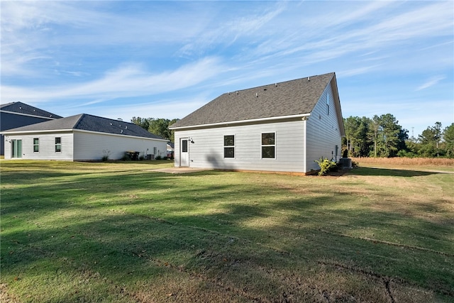 rear view of property featuring a lawn