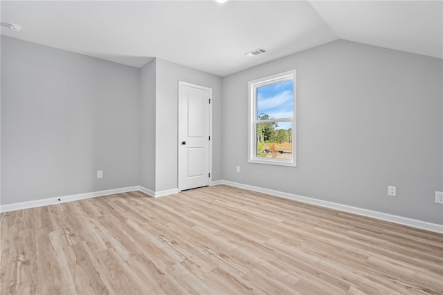 additional living space featuring light hardwood / wood-style floors and vaulted ceiling