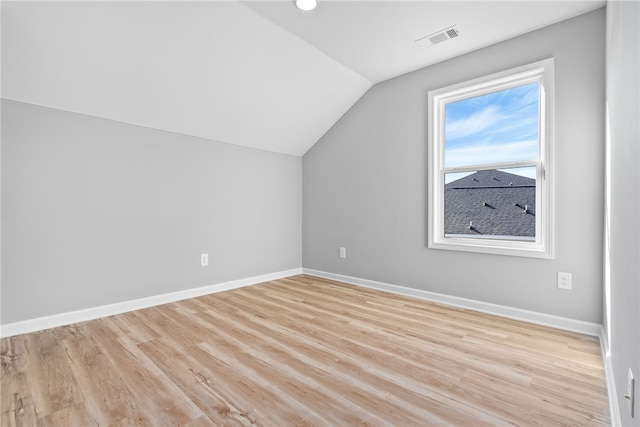 additional living space with light wood-type flooring and lofted ceiling