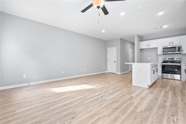 kitchen featuring ceiling fan, light hardwood / wood-style flooring, backsplash, white cabinets, and appliances with stainless steel finishes