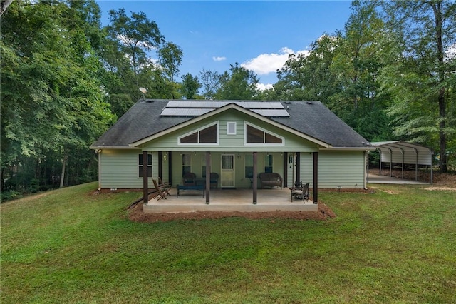 rear view of house featuring a patio, a yard, and a carport