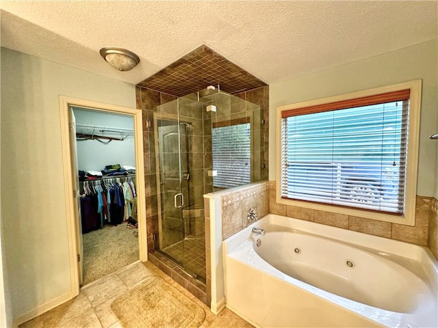 bathroom featuring tile patterned floors, plus walk in shower, and a textured ceiling