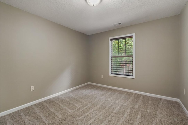 carpeted empty room with a textured ceiling