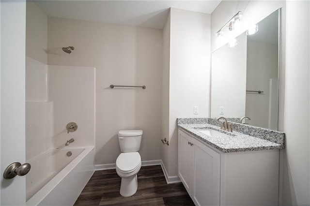 full bathroom with toilet, shower / washtub combination, wood finished floors, baseboards, and vanity