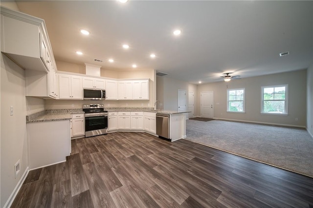 kitchen featuring a peninsula, open floor plan, visible vents, and appliances with stainless steel finishes