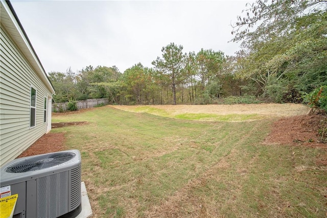 view of yard with central AC unit and fence