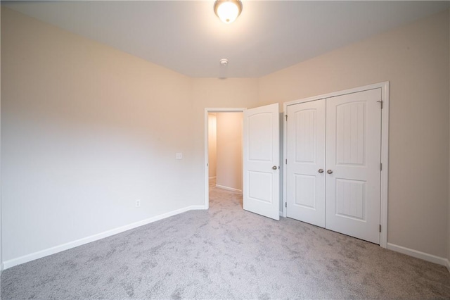 unfurnished bedroom featuring a closet, baseboards, and carpet