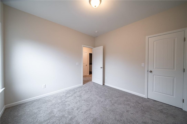 unfurnished bedroom featuring baseboards and carpet