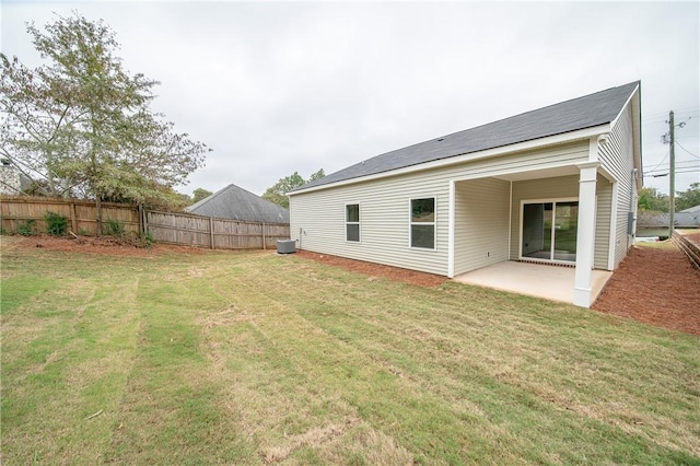 back of property featuring a yard, a patio area, fence, and roof mounted solar panels