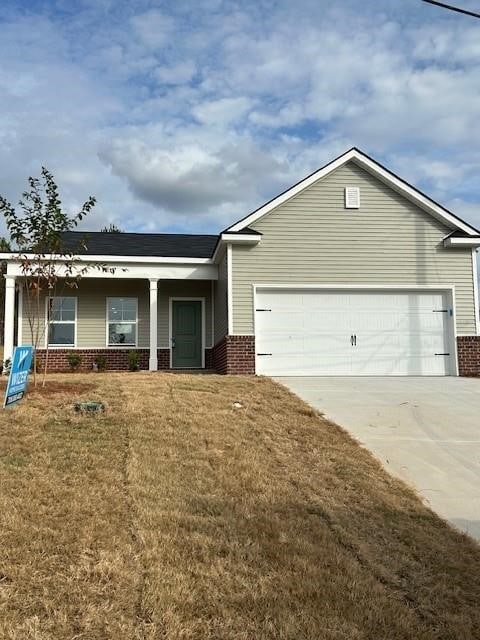 single story home featuring a garage, brick siding, concrete driveway, and a front yard