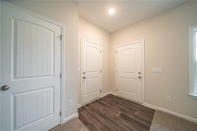 entryway with dark wood finished floors and baseboards