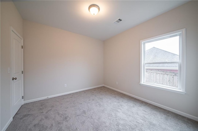 carpeted empty room featuring visible vents and baseboards