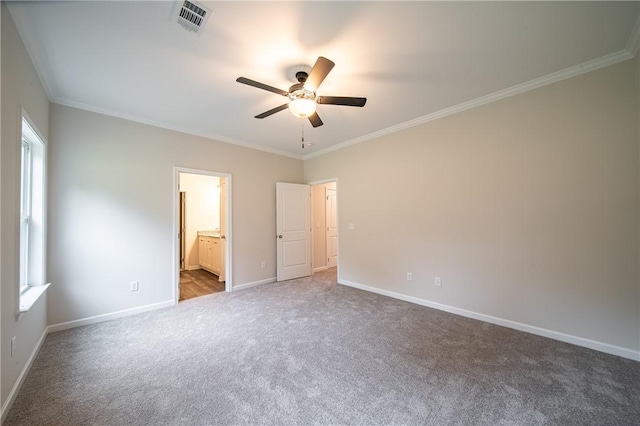 unfurnished bedroom featuring visible vents, ensuite bath, carpet, crown molding, and baseboards