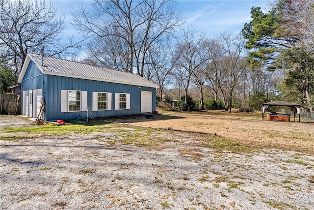 view of side of property featuring a garage, metal roof, and board and batten siding