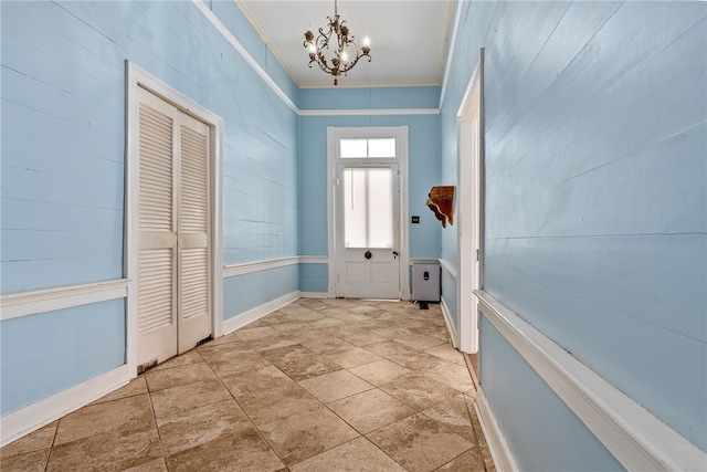 doorway to outside with ornamental molding and a notable chandelier