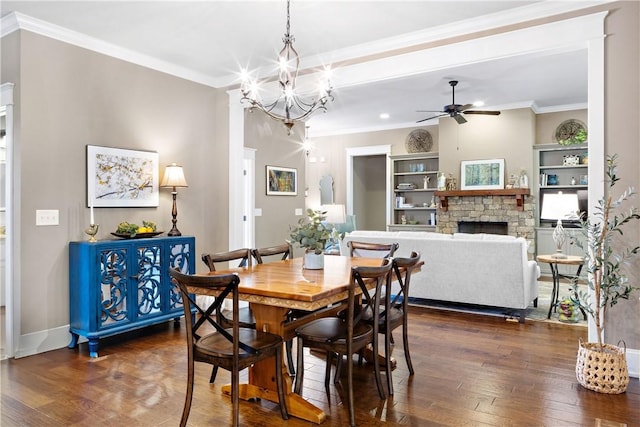 3102 Quail Run, Opelika, AL 36801 - dining area featuring a ceiling fan, dark wood-style flooring, a stone fireplace, a chandelier, and crown molding