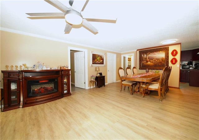 dining area with light hardwood / wood-style floors, ornamental molding, and ceiling fan