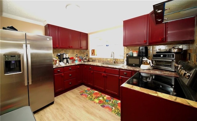 kitchen featuring backsplash, sink, crown molding, light hardwood / wood-style flooring, and stainless steel appliances