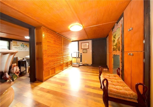 hallway with light hardwood / wood-style floors and wooden ceiling