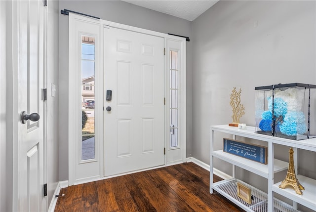 foyer entrance featuring dark wood-type flooring and a textured ceiling