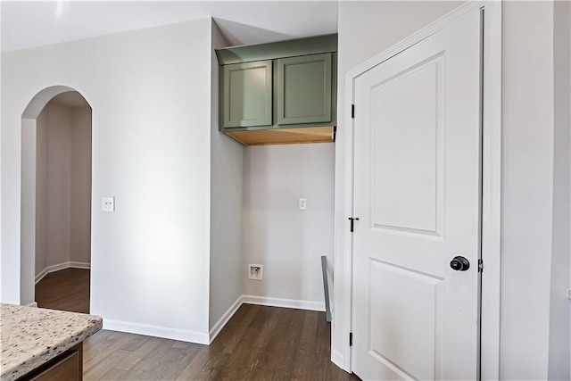 clothes washing area with dark wood-type flooring