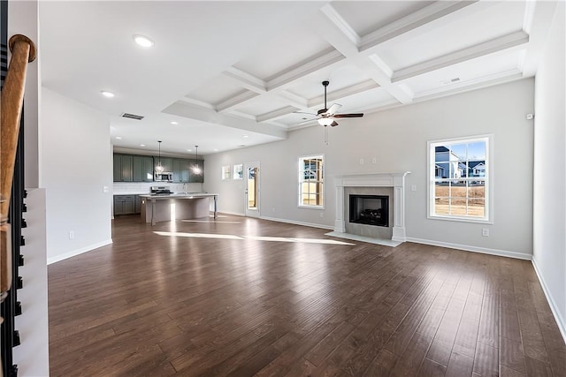 unfurnished living room featuring beam ceiling, a premium fireplace, dark wood-type flooring, and coffered ceiling