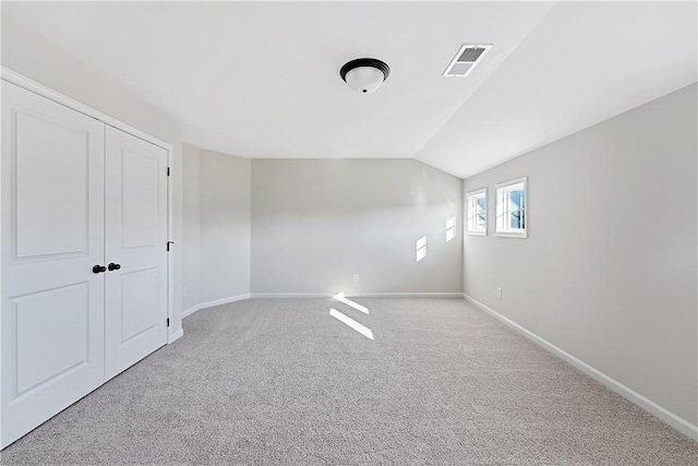 interior space featuring light colored carpet and lofted ceiling