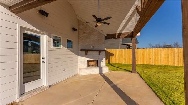 view of patio with an outdoor brick fireplace and ceiling fan