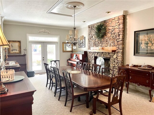 335 Forsythia Ct, Auburn, AL 36830 - dining area with light colored carpet, french doors, ornamental molding, a chandelier, and a fireplace