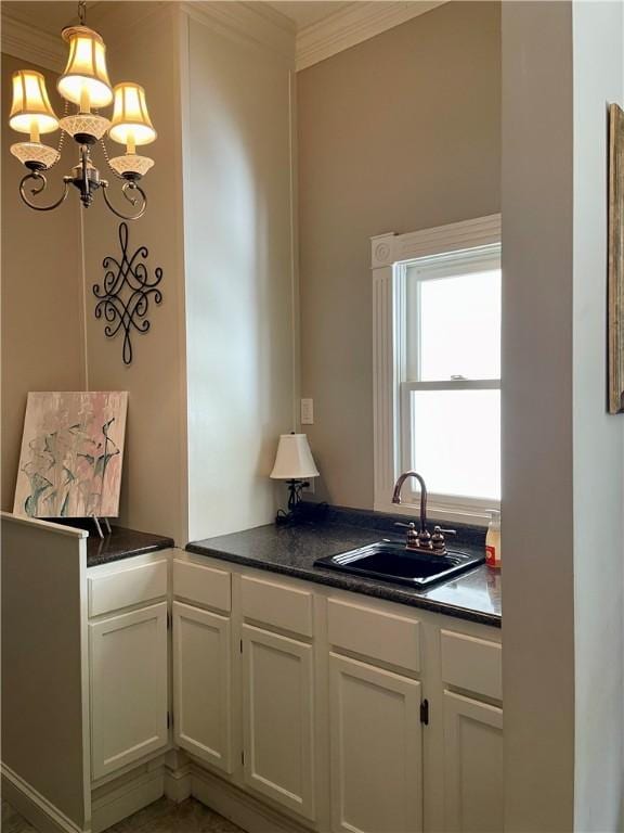335 Forsythia Ct, Auburn, AL 36830 - kitchen with dark countertops, white cabinetry, crown molding, a chandelier, and pendant lighting
