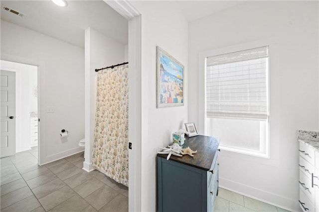 bathroom featuring vanity, tile patterned floors, and toilet