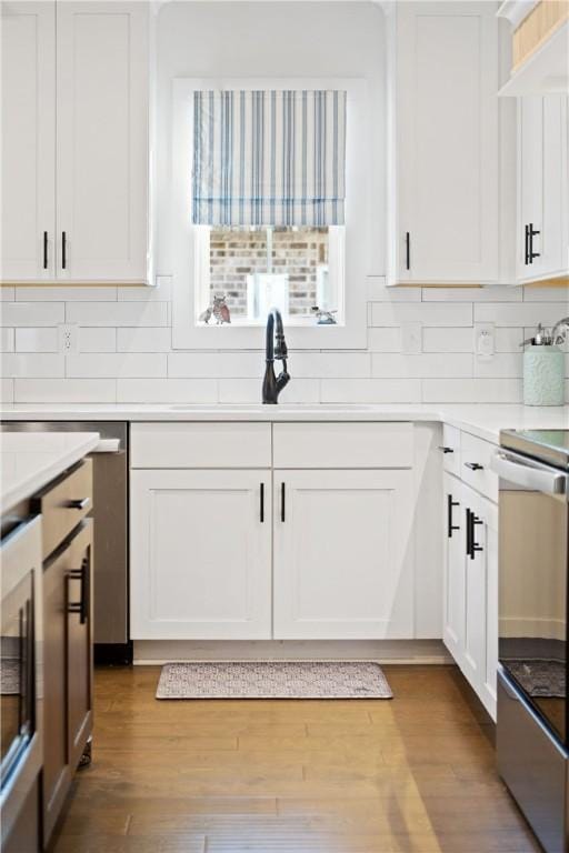 kitchen featuring electric range, wood-type flooring, and white cabinets