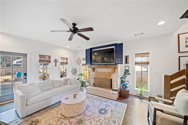 living room with ceiling fan, dark hardwood / wood-style floors, and a fireplace