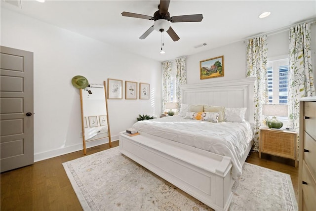 bedroom with dark hardwood / wood-style flooring and ceiling fan