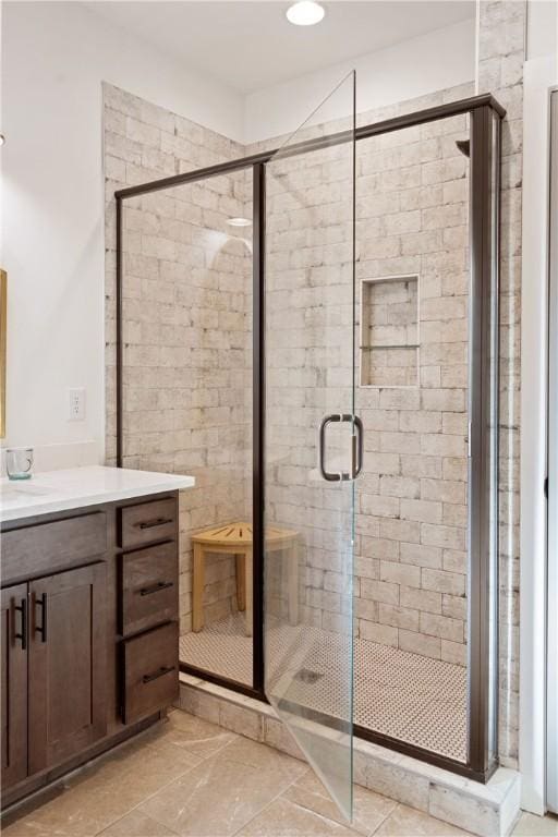 bathroom with vanity and a shower with door