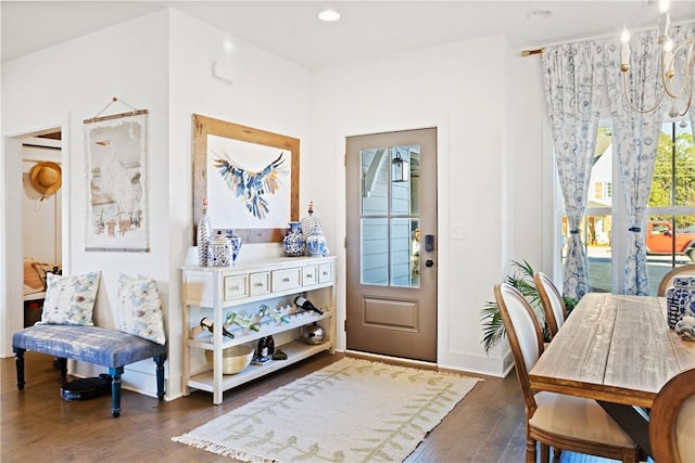 entryway with dark wood-type flooring and a notable chandelier