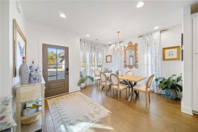 dining area with hardwood / wood-style flooring and an inviting chandelier