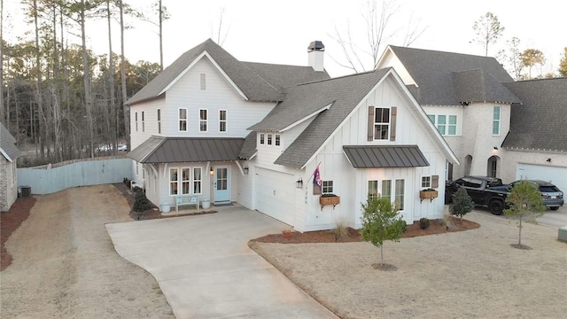 rear view of property featuring central AC and a garage