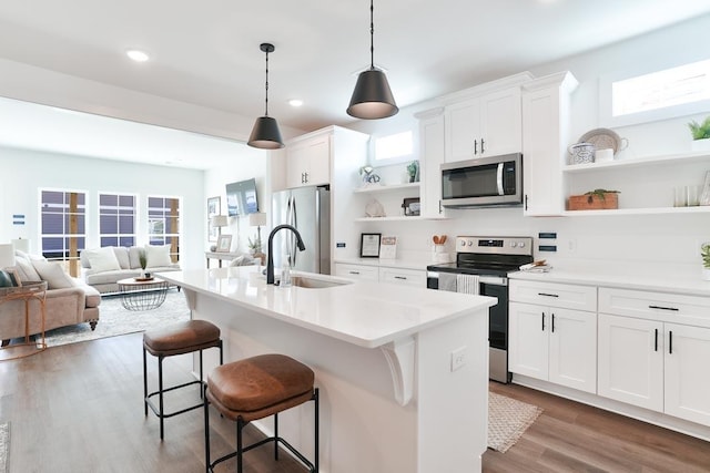 108 Hunters Way, Opelika, AL 36801 - kitchen featuring stainless steel appliances, open shelves, dark wood-type flooring, a kitchen breakfast bar, and an island with sink