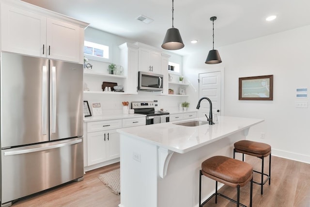 108 Hunters Way, Opelika, AL 36801 - kitchen featuring appliances with stainless steel finishes, open shelves, light wood-style flooring, a breakfast bar area, and recessed lighting