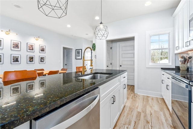 kitchen with recessed lighting, light wood-style flooring, appliances with stainless steel finishes, white cabinets, and a sink