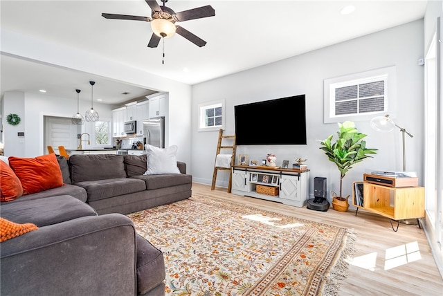 living area featuring light wood-style flooring, recessed lighting, a ceiling fan, and baseboards