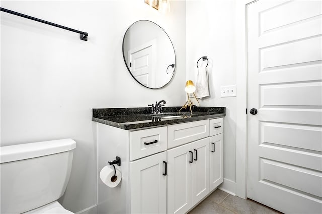 half bathroom with tile patterned floors, toilet, and vanity