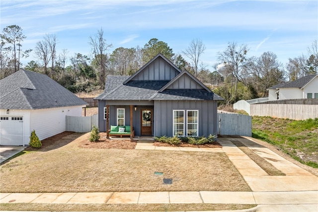 view of front of home with roof with shingles, board and batten siding, and fence