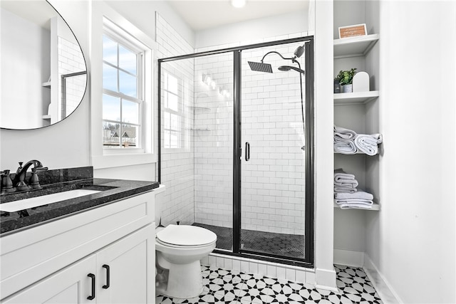 full bathroom featuring a stall shower, toilet, vanity, and baseboards