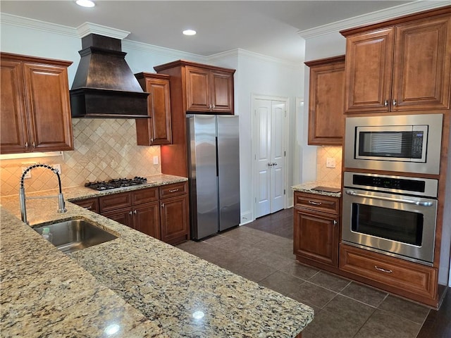 kitchen with a sink, custom exhaust hood, light stone countertops, and stainless steel appliances