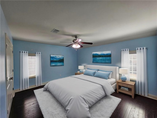 bedroom with visible vents, baseboards, ceiling fan, and hardwood / wood-style flooring