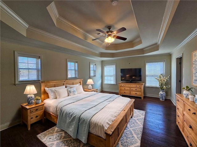 bedroom with dark wood finished floors, baseboards, a tray ceiling, and ornamental molding