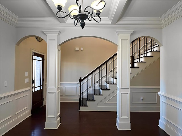 foyer with wood finished floors, arched walkways, stairs, crown molding, and a chandelier